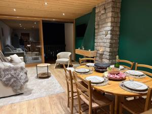 a dining room with a wooden table and chairs at Morz'Inn Vue panoramique sur les montagnes in Morzine