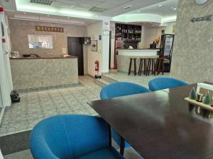 a restaurant with blue chairs and a table and a bar at Cristal Sinaia in Sinaia