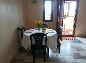 a dining room table with a vase of flowers on it at Coorg mansion in Madikeri +23 photos