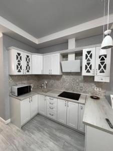 a white kitchen with white cabinets and a sink at Апартаменты Аркадия Гагарин Плаза У моря Без комиссии in Odesa