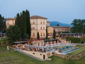 a resort with a pool in front of a building at Castello di Casole, A Belmond Hotel, Tuscany in Casole dʼElsa