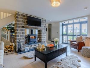 a living room with a stone fireplace with a tv at 3 Bed in Alnwick oc-77571 in Craster