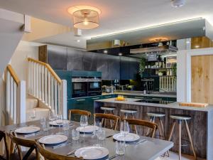 a dining room with tables and chairs and a kitchen at 3 Bed in Alnwick oc-77571 in Craster