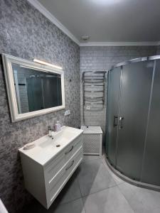 a bathroom with a white sink and a shower at Апартаменты Аркадия Гагарин Плаза У моря Без комиссии in Odesa +25 photos