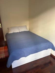 a bed in a room with a blue blanket at Caniço Easy Stay in Caniço