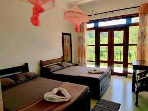 a bedroom with two beds and a large window at New Wasala Guest in Diyatalawa +32 photos