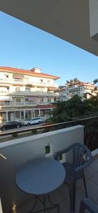 a table and a chair on a balcony with a building at Sunrise1 in Paralia Katerinis
