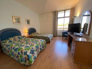 a hotel room with two beds and a flat screen tv at Rabieh Guest house in Rabieh