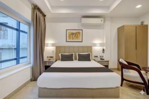a bedroom with a large bed and a window at Soorya in Attingal +19 photos
