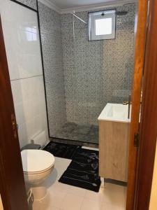 a bathroom with a shower and a toilet and a sink at Caniço Easy Stay in Caniço +3 photos