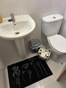 a bathroom with a sink and a toilet and a bidet at Caniço Easy Stay in Caniço