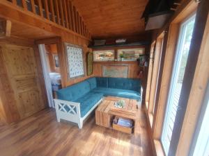 a living room with a blue couch and a table at Gluba Treetop Cabins Furunåla in Harkmark