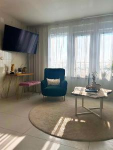 a living room with a blue chair and a table at Secret Place apartments, luxury and spa in Zdenci Brdovečki