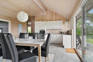 a dining room and kitchen with a table and chairs at 20422-Samso-Egernvej-16 in Ballen