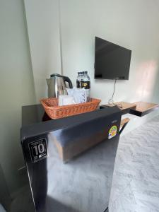 a desk with a television and a basket on it at SiLin Hotel in Ban Nong Pling