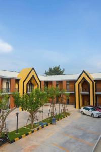 a building with a car parked in a parking lot at SiLin Hotel in Ban Nong Pling
