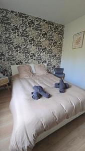 two teddy bears on a bed in a bedroom at L'ALPETTE maison 3 pièces 2 chambres tout confort in Vernouillet