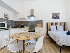 a kitchen with a table and chairs and a bed at Le Pianiste in Voiron
