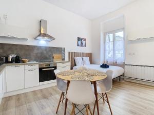 a kitchen and dining room with a table and a bed at Le Pianiste in Voiron +9 photos