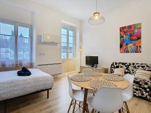 a room with a table and a bed and a couch at Le Pianiste in Voiron