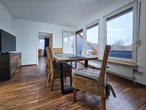 a dining room with a table and chairs and windows at Alpha Apartments in Datteln