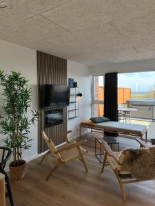 a living room with a fireplace and a table and chairs at HYGGE Strand Camping in Odder