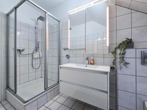 a white bathroom with a shower and a sink at Alpha Apartments in Datteln
