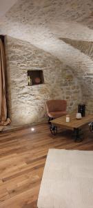 a living room with a table and a stone wall at A l'ombre des sentiers in Cuisiat