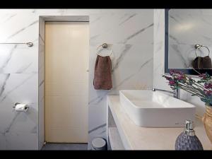 a white bathroom with a sink and a mirror at Sunflower Villa in Franschhoek in Franschhoek +34 photos