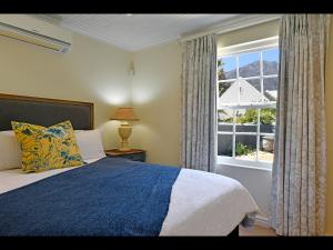 a bedroom with a bed and a large window at Sunflower Villa in Franschhoek in Franschhoek