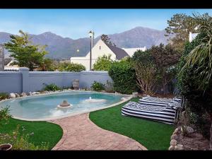 a swimming pool with two lounge chairs in a yard at Sunflower Villa in Franschhoek in Franschhoek