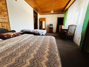 a room with two beds and a dining room with a table at У Тараса і Лесі in Yaremche