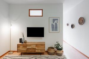 a living room with a tv on a white wall at Modern studio near Metro in Senhora da Hora