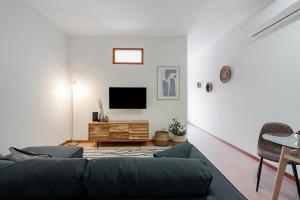a living room with a couch and a tv at Modern studio near Metro in Senhora da Hora