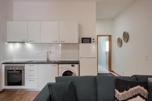 a living room with a couch and a kitchen at Modern studio near Metro in Senhora da Hora +22 photos