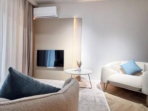 a living room with a couch and a table at YANG 23rd Floor Panoramic View & King Bed, Parkin in Cluj-Napoca