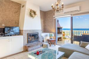 a living room with a fireplace and a view of the ocean at Villa Beach Heaven in Pomos
