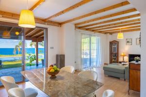 a kitchen and living room with a table and chairs at Villa Beach Heaven in Pomos