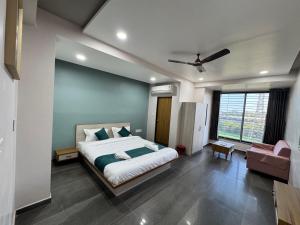 a bedroom with a bed and a couch and a window at Hotel Jb Classic in Himatnagar +27 photos