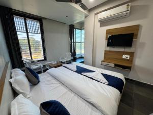 a bedroom with a bed and a flat screen tv at Hotel Jb Classic in Himatnagar