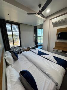 a bedroom with a large bed with a ceiling fan at Hotel Jb Classic in Himatnagar