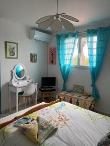 a bedroom with a bed and a desk and a window at La Salamandre 66 in Saint-Génis