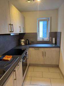 eine kleine Küche mit Spüle und Fenster in der Unterkunft Apartment Simone in Lörrach