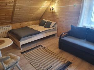 a small room with a bed and a couch at Chata Venus in Bóbrka