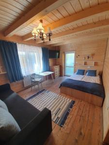 a bedroom with two beds and a couch in a room at Chata Venus in Bóbrka