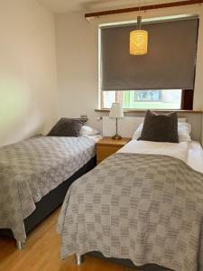 two beds in a room with a window at BSG Apartments in Selfoss
