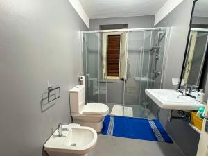 a bathroom with a toilet and two sinks and a shower at B&B - Studio Arcodia in San Marco dʼAlunzio