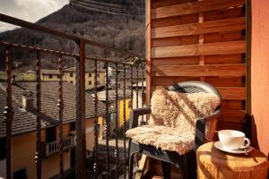a cup of coffee sitting on a table on a balcony at Hotel Morandi in Valbondione