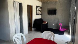 a living room with a pink flamingo sitting in a chair at Prive Dona Valentina in Itamaracá