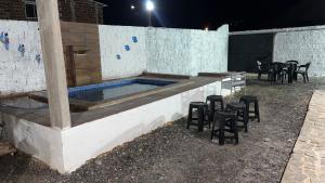 a swimming pool with stools and a table and chairs at Prive Dona Valentina in Itamaracá